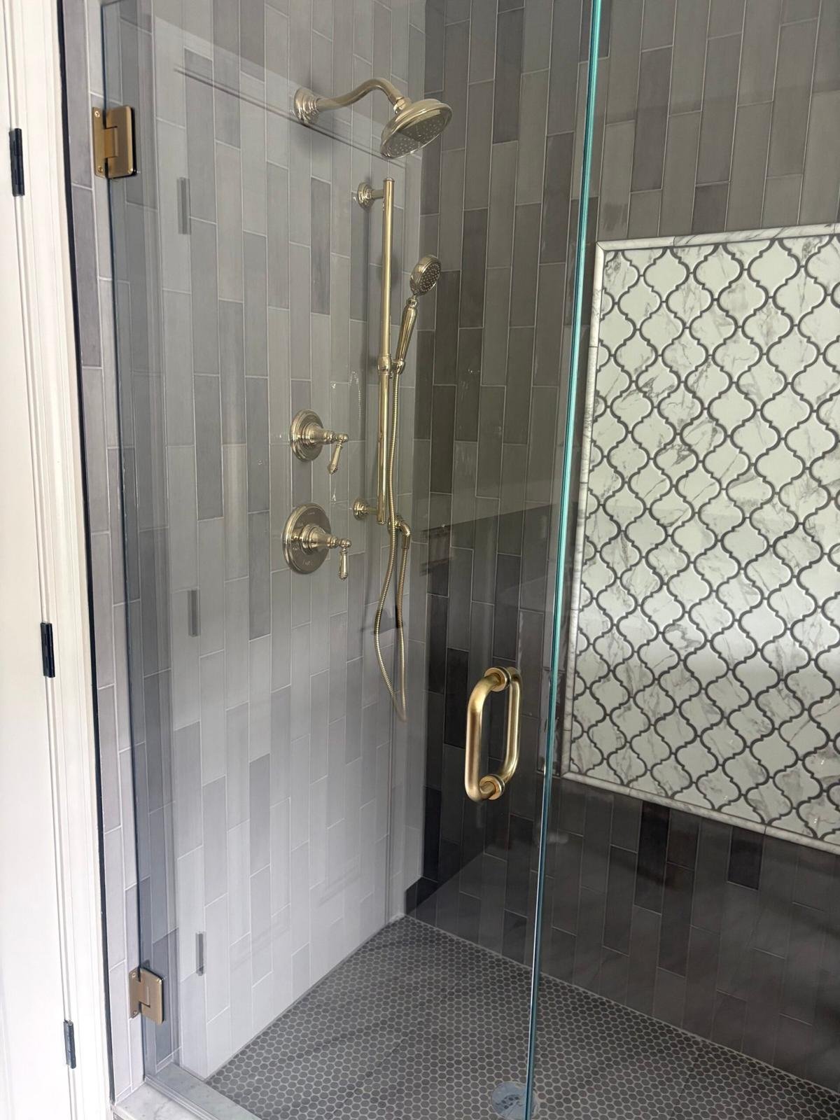 Shower with handheld slide bar, brass fixtures and gray plank tile