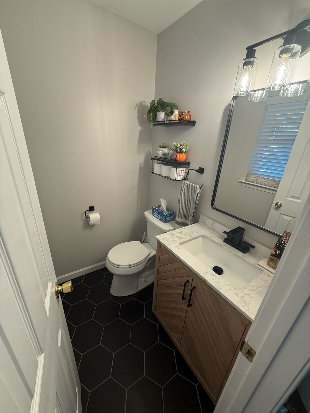 Small bathroom after remodel with black hex tile floor, wood vanity and black fixtures, Middletown NY